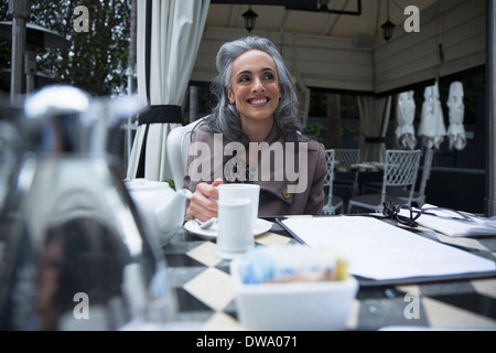 Mature woman having coffee break on luxury porch Stock Photo
