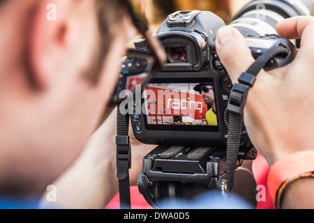 Close up of photographer checking photograph of mountain biker on camera Stock Photo