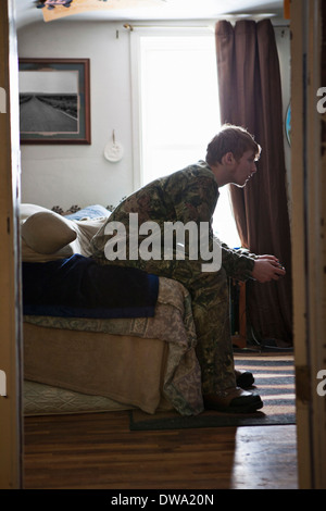 Teenage boy sitting on sofa concentrating on video game Stock Photo