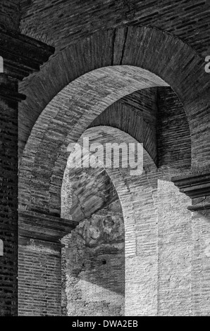 A monochromatic close up view of some of the many arches that make up the impressive colosseum ruin in Rome, Italy. Stock Photo