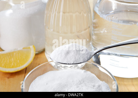 Eco-friendly natural cleaners. Vinegar, baking soda, salt, lemon and cloth on wooden table. Homemade green cleaning. Stock Photo