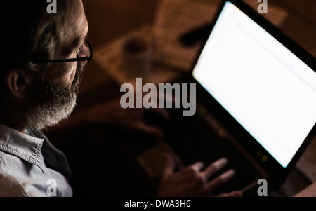 Mature man using laptop with blank screen Stock Photo