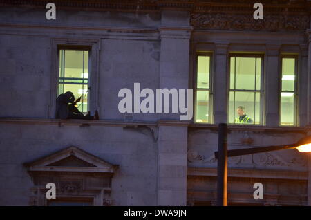 Cardiff, Wales, UK, March 4th 2014. Police were called after a man climbed out on to a window ledge of the highest floor of Cardiff Civil Justice Centre. He appeared to have soething tied around his waist and was grasping papers. Crowds gathered and police closed Haverlock street and Park street, causing widespread disruption. Police were arrived at 16.04. Credit: Tom Guy/Alamy Live News Stock Photo