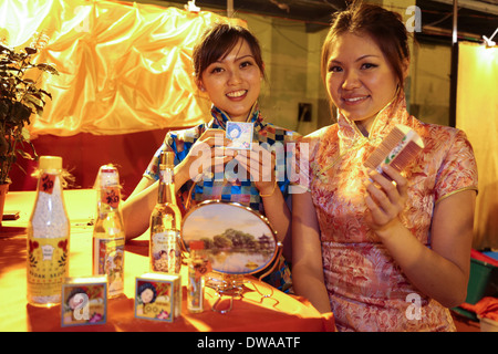 Young volunteers dressed in cheongsam for photo takings by the crowds at the Penang Chinese New Year fiesta 2014 at Malaysia. Stock Photo