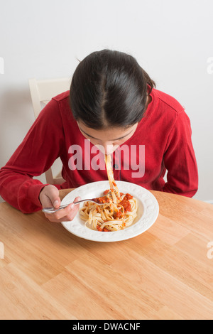Teenage girl eating pasta Stock Photo