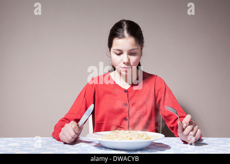 Teenage girl eating pasta Stock Photo