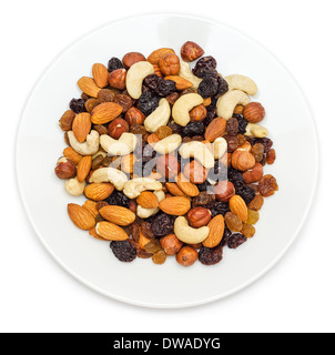 Mixed nuts and dry fruits in plate isolated on white background Stock Photo
