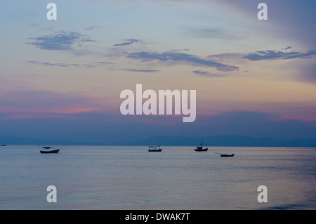 Small fishing boats anchor near bay in the evening Stock Photo