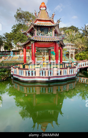 SINGAPORE - FEBRUARY 1, 2014: Buddha Statue Altar in Chinese Pavilion by the lake at Haw Par Villa Theme Park. Stock Photo