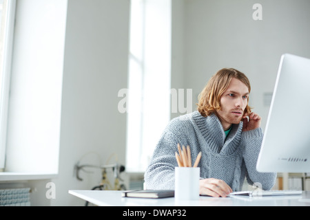 Portrait of serious guy working with computer in office Stock Photo