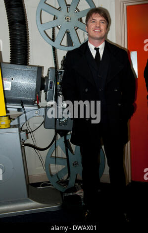 Brynmawr, Baenau Gwent, Wales, UK. 4th March 2014. Jonny Owen in the foyer of Market Hall cinema with original 35mm film projector. Merthyr Tydfil’s very own Jonny Owen premieres his latest film SVENGALI, co-starring Vicky McClure, which was shot on location in the Welsh mining valleys. The premiere is held at the oldest independent cinema in Wales – The Market Hall Cinema in Brynmawr. Credit:  Graham M. Lawrence/Alamy Live News. Stock Photo