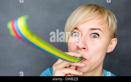 portrait of woman blowing a party blower Stock Photo