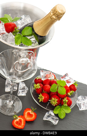 champagne and two glasses over white background. festive arrangement with sparkling wine and fresh heart shaped strawberries. Stock Photo