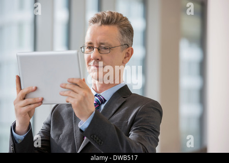 Businessman looking at digital tablet in office Stock Photo