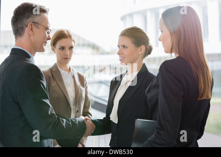 Confident business people shaking hands at workplace Stock Photo