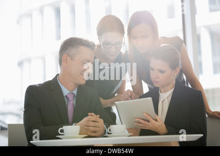 Business people using digital tablet together in office cafeteria Stock Photo