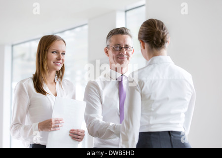 Confident business people shaking hands in office Stock Photo