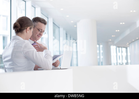 Business people working at railing in office Stock Photo
