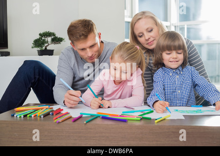 Mid adult parents with children drawing together at home Stock Photo