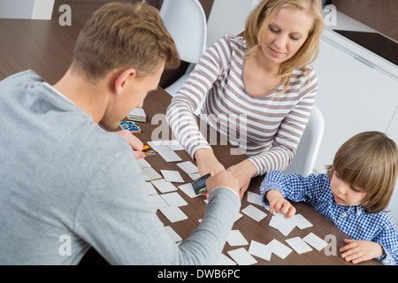 Family of three playing cards at home Stock Photo