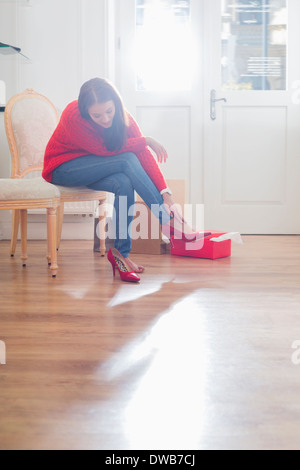 Full length of young woman trying on footwear in store Stock Photo