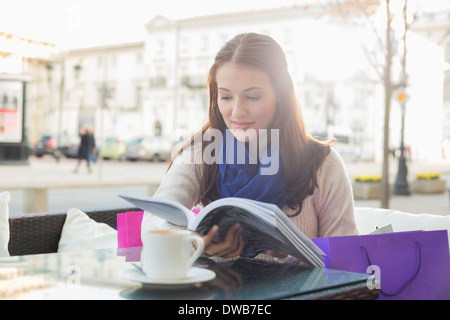 Beautiful woman reading book at sidewalk cafe Stock Photo