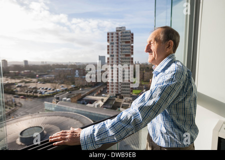Side view of senior man standing on balcony Stock Photo
