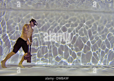 A US Navy search and rescue swimmer performs underwater kettle bell walks to increase lung power and endurance during training at Joint Base Pearl Harbor-Hickam February 27, 2014 in Honolulu, Hawaii. Stock Photo