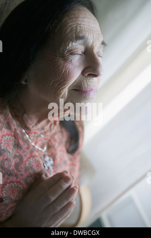 Senior woman praying Stock Photo