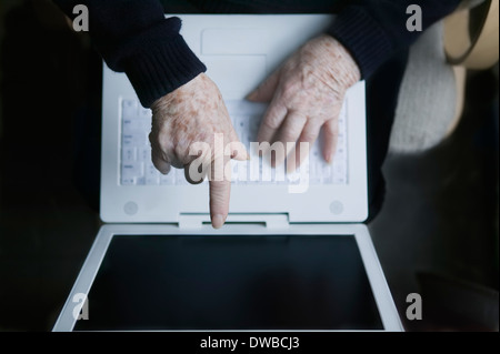 Senior woman pointing at laptop screen Stock Photo