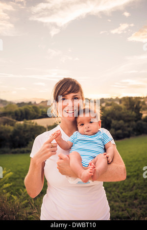 Portrait of baby girl gripping mothers finger