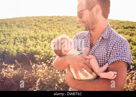 Mid adult man holding baby daughter
