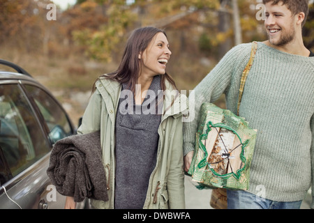 Couple carrying camping equipment by car Stock Photo