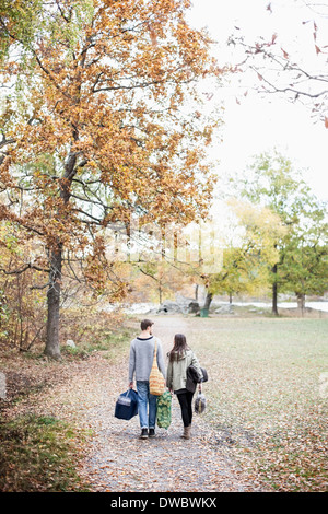 Rear view of couple walking in forest Stock Photo