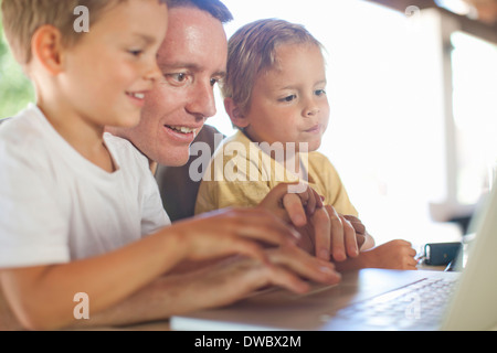 Father and sons using laptop Stock Photo