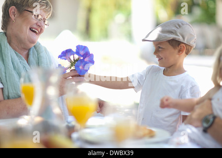 Boy giving flowers to grandmother Stock Photo