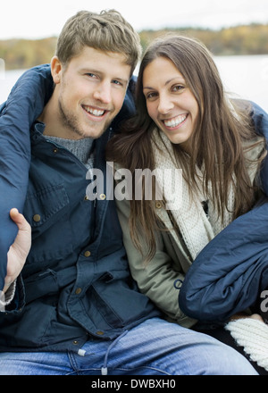 Portrait of happy couple wrapped in blanket Stock Photo