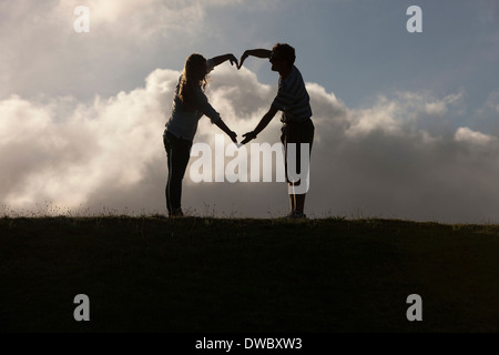 Couple forming heart shape with hands Stock Photo