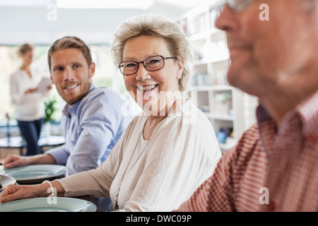 Portrait of happy senior woman sitting with family at dining table Stock Photo