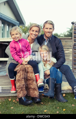 Portrait of happy two generation family sitting together in yard Stock Photo