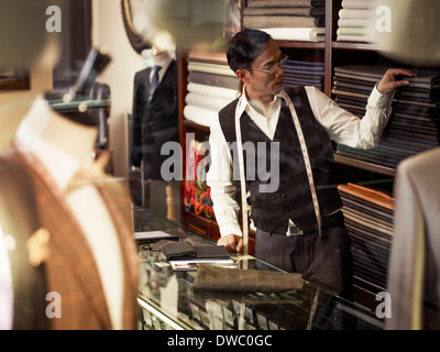 Tailor choosing fabric in traditional tailors shop Stock Photo