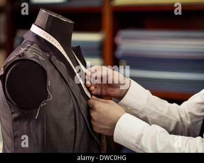 Tailor measuring garment in traditional tailors shop Stock Photo