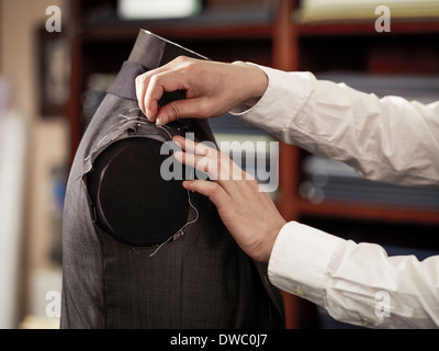 Tailor pinning garment in traditional tailors shop Stock Photo