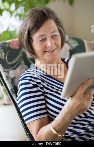 Smiling senior woman using digital tablet at home Stock Photo