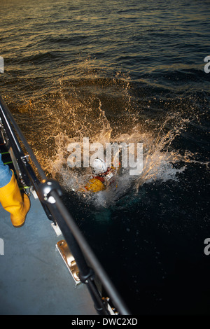 Lifeboat crew training with team member in sea Stock Photo