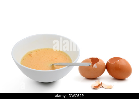 Beaten egg yolks in cup with eggshell Stock Photo