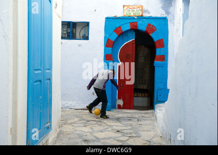 North Africa, Tunisia, Hammamet, young boy playing football in the Medina. Stock Photo