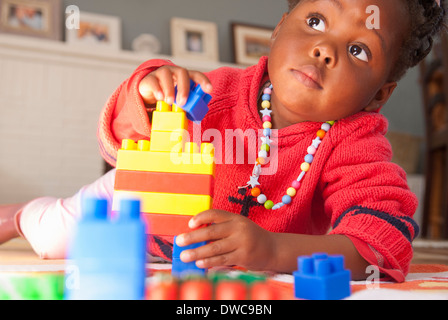 Female toddler playing with building blocks Stock Photo