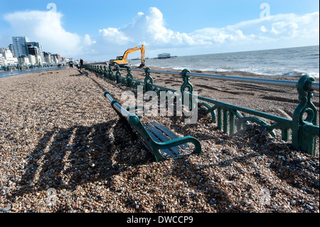 Brighton Beach after storms that drove thousands of tons of shingle and pebbles from the beach up onto the promenade, swamping the benches on the prom. Stock Photo