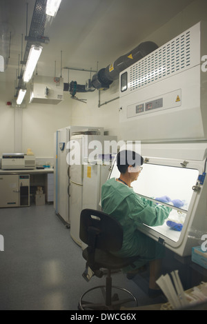 Scientist working behind screen of scientific machine Stock Photo